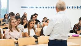 foto di un'aula con studenti e un professore di spalle